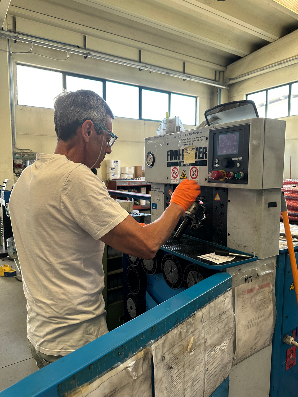 Operatore di macchina industriale in azione presso lo stabilimento Eram per le forniture industriali.