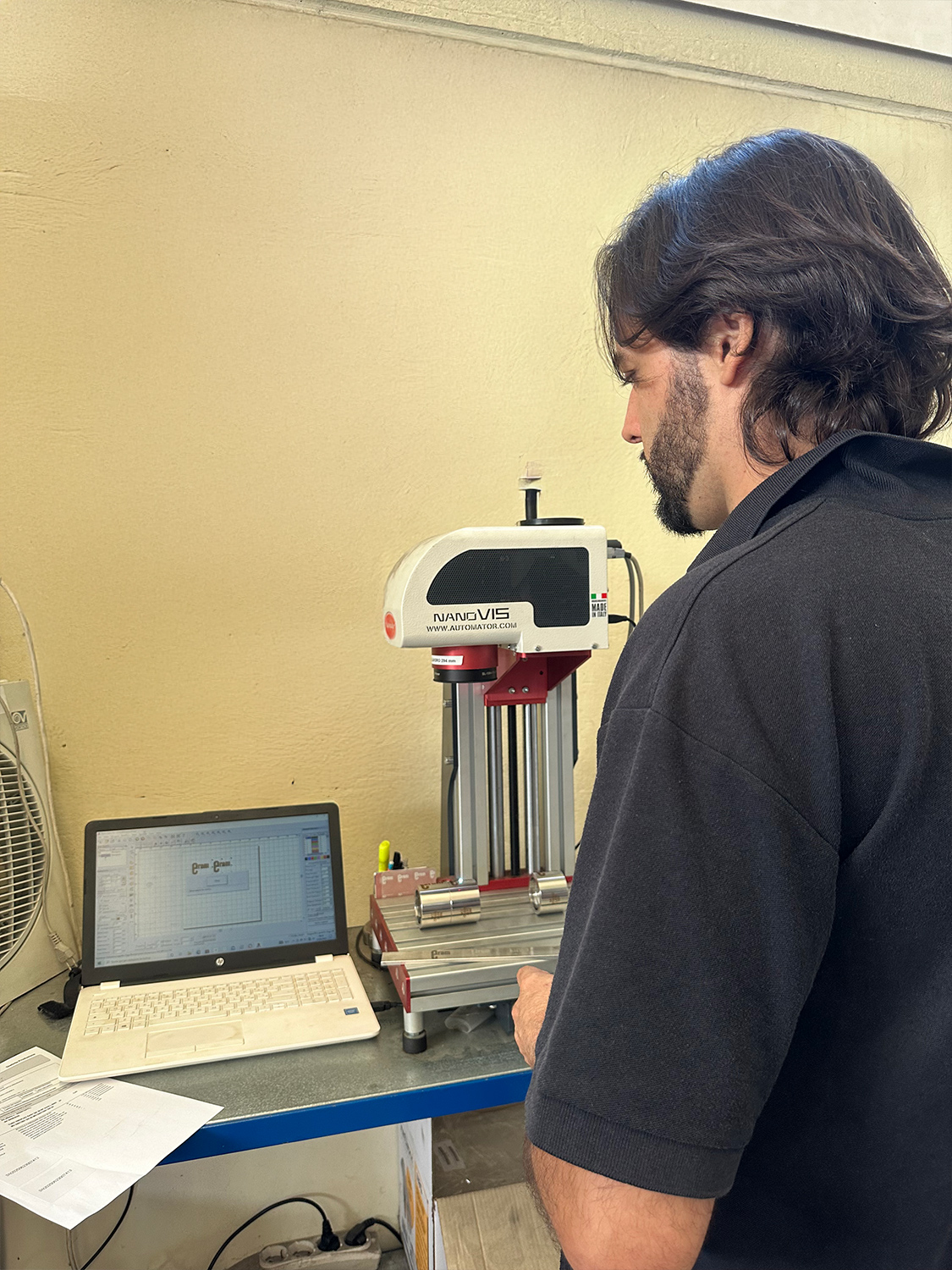 Operatore usa il dispositivo NanoVIS per forniture industriali in un ambiente di lavoro.