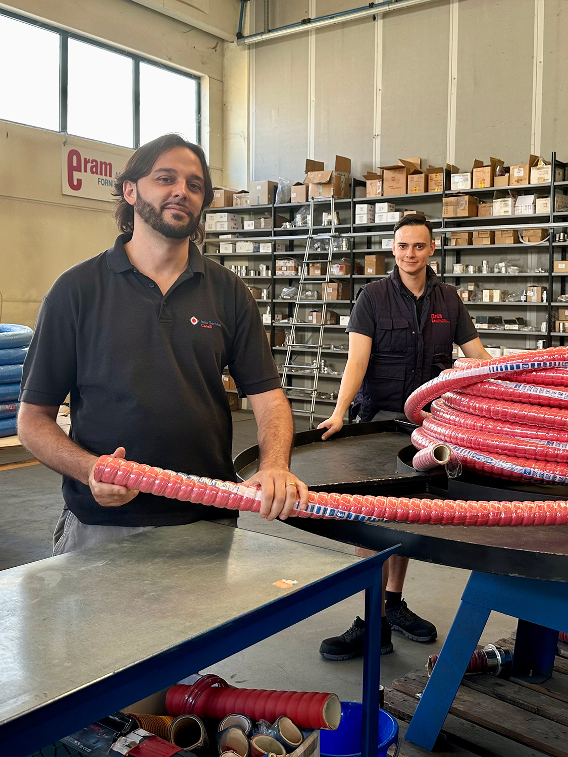 Operatori di Eram nel magazzino, specializzati in forniture industriali e tubi flessibili.