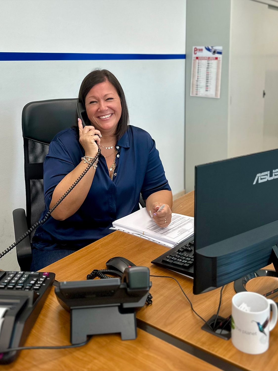 Dipendente Eram al telefono, sorridente, durante attività di assistenza clienti in ufficio.